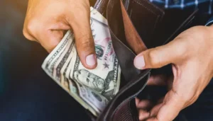 Person looking at cash in their wallet